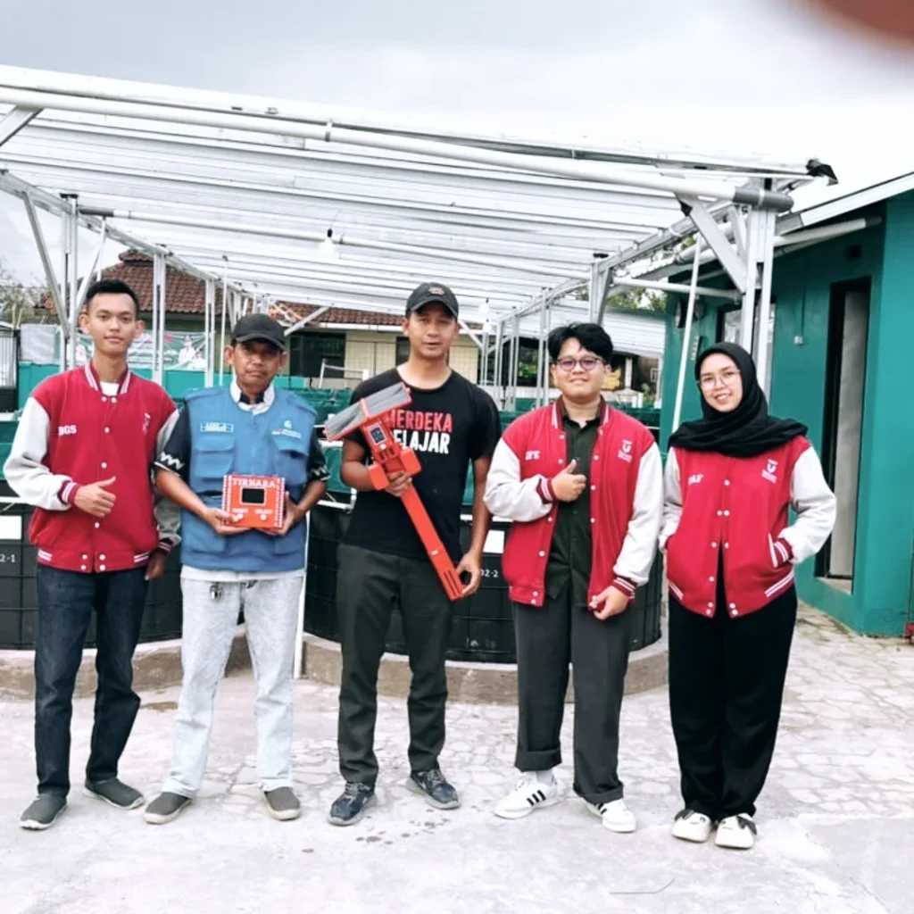 Tiga mahasiswa Telkom University bersama pengurus BUMDes Artha Cipta Pakutandang sedang memamerkan inovasi alat pemantau kualitas air berbasis sensor dan IoT bernama Tirnara